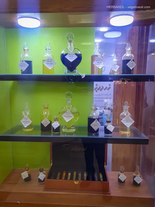 Glass display case of labeled herbal extract bottles in amber and green