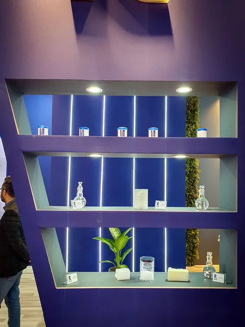 Purple shelving unit displaying sample containers, a plant, and product cards