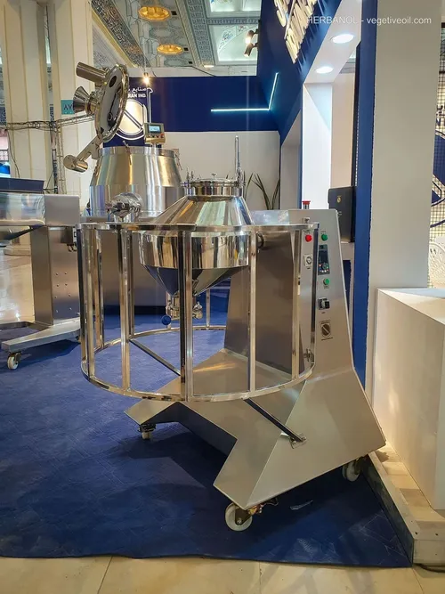 Two stainless conical processing vessels on wheeled frames in booth