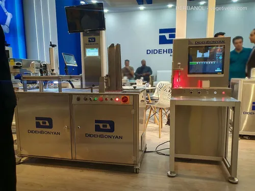 Two DidehBonyan vision inspection machines with monitors among visitors