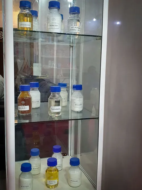 Glass cabinet of labelled chemical sample bottles on multiple shelves