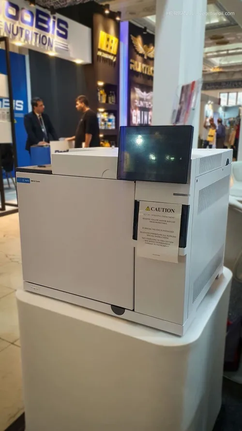 White Agilent gas chromatography system on pedestal; booths behind