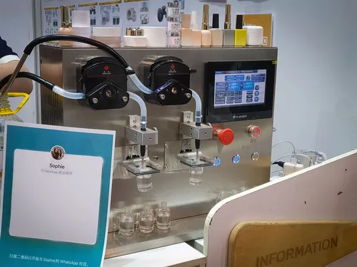 Twin-head peristaltic liquid filling machine with touchscreen on a counter