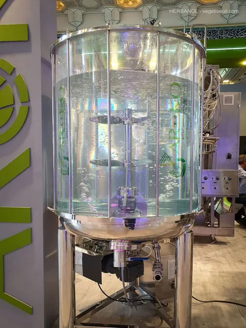 Tall transparent vessel with bubbling water and internal agitator on stand