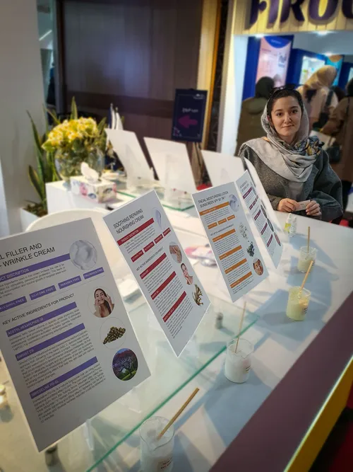Woman seated behind a table of skincare product cards and samples