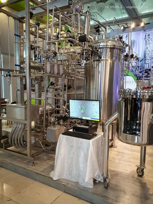 Stainless bioreactor skid with control monitor on cloth-covered table