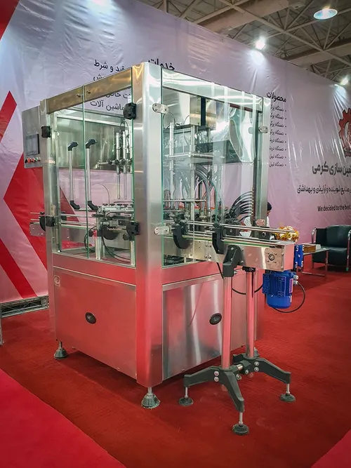Stainless steel automatic bottle filling machine on red exhibition carpet