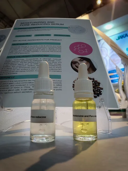 Two dropper bottles in front of a serum description card